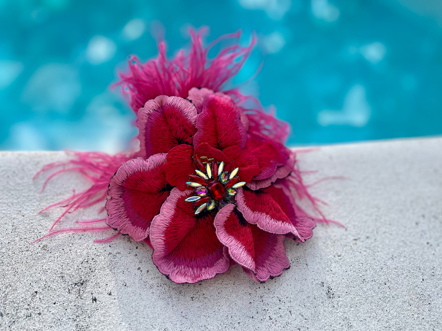 Pink and red floral fascinator with feathers and bejeweled center